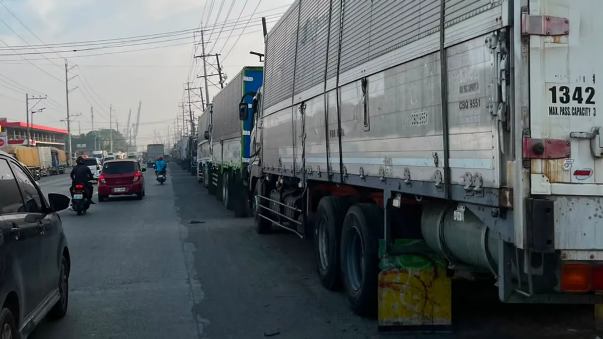 Line of container trucks parked along the highway shoulder