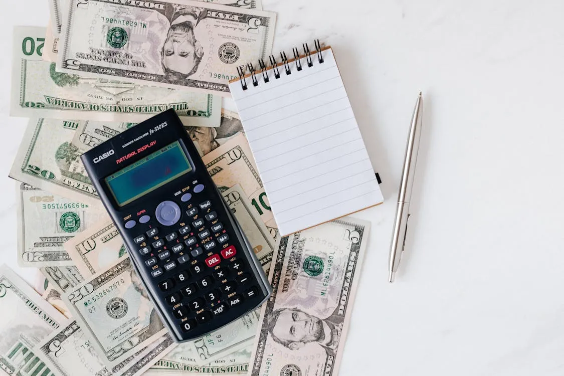 Calculator and Philippine peso bills for computing Davao freelancer service invoice totals post-EOPT